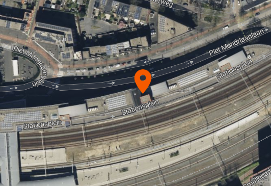 Aerial map centered on Stationsplein, with an orange marker identifying the selected rail asset.